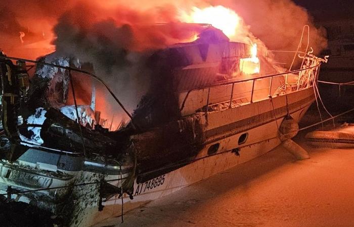 Incendie impressionnant sur un bateau en pleine nuit dans un port, opérations de confinement menées pour éviter tout risque de pollution