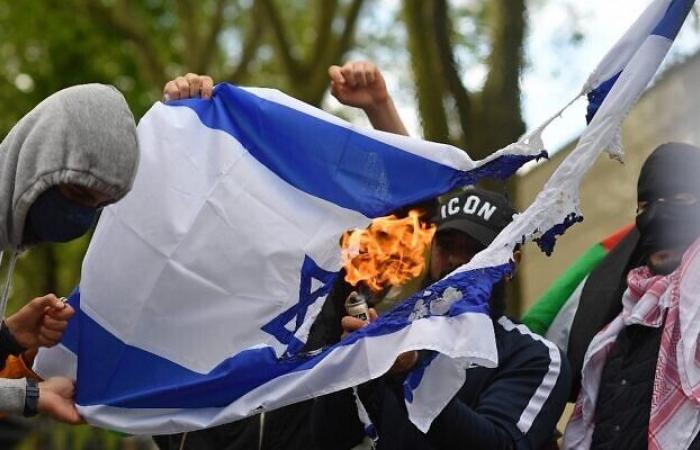 une femme brûle le drapeau israélien lors d’une réunion d’étudiants juifs