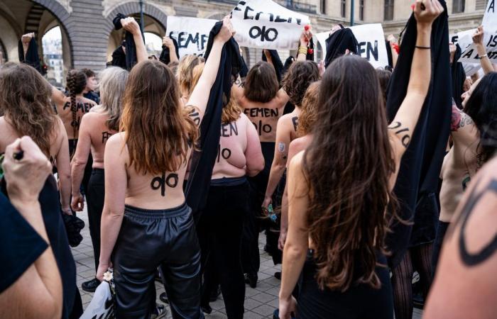 Des militantes Femen manifestent devant la pyramide du Louvre